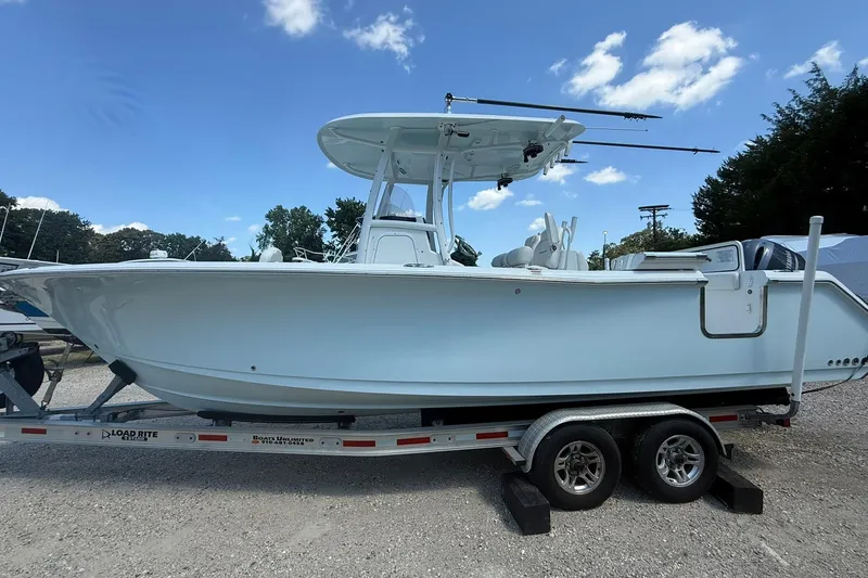 Slide: The Image of 2015 Sea Hunt Gamefish 27 boat on trailer under clear blue sky. - 6