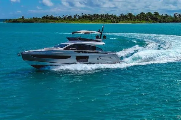Slide: The Image of 2024 Azimut S7 yacht cruising on turquoise waters near a lush island. - 2