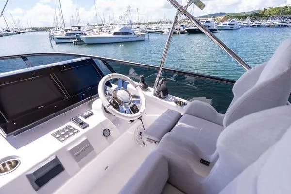 Slide: The Image of 2024 Azimut S7 yacht helm with modern controls, overlooking a marina with docked boats. - 22