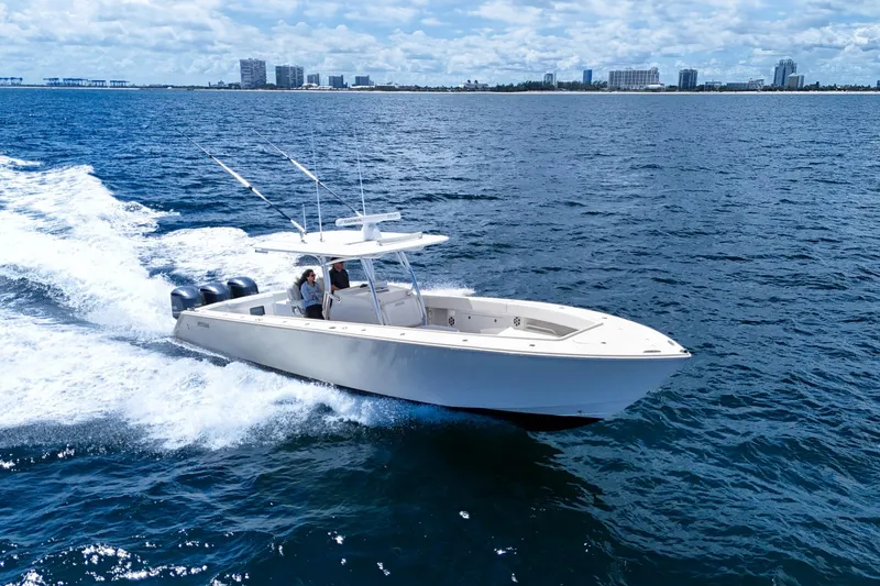 Slide: The Image of 2018 Jupiter 38 FS boat cruising on open water near a city skyline. - 2