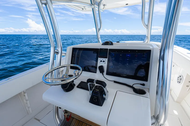 Slide: The Image of 2018 Jupiter 38 FS boat console with dual screens, steering wheel, and ocean view. - 20