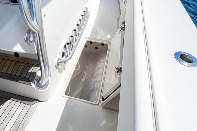 Slide: The Image of 2018 Jupiter 38 FS boat deck with open storage compartment and rod holders. - 22