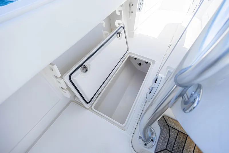 Slide: The Image of Open storage compartment on 2018 Jupiter 38 FS boat deck, featuring sleek white design. - 29