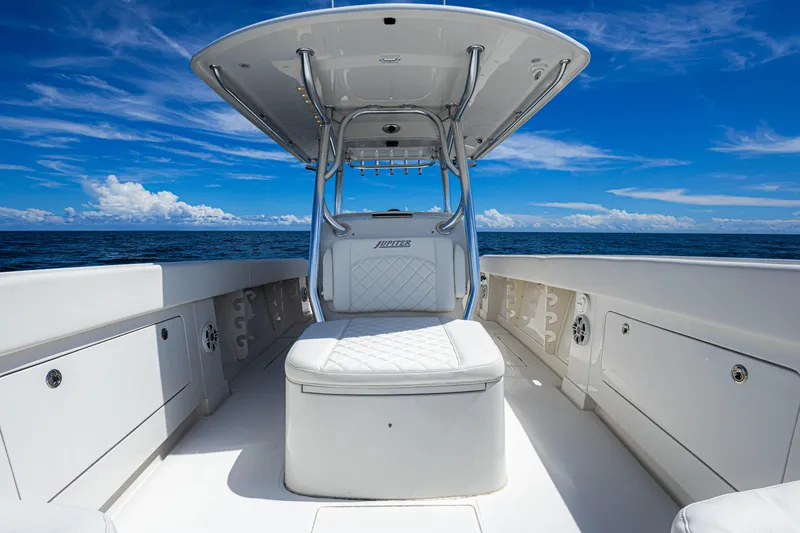 Slide: The Image of 2018 Jupiter 38 FS boat interior with white seating, under a clear blue sky. - 37