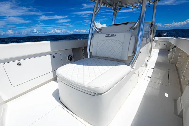 Slide: The Image of 2018 Jupiter 38 FS boat interior with white seating, ocean view, and clear blue sky. - 38