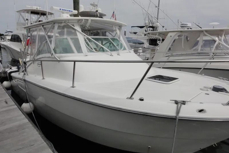 Slide: The Image of 2002 Rampage 30 Open boat docked at marina, featuring sleek design and fishing equipment. - 10