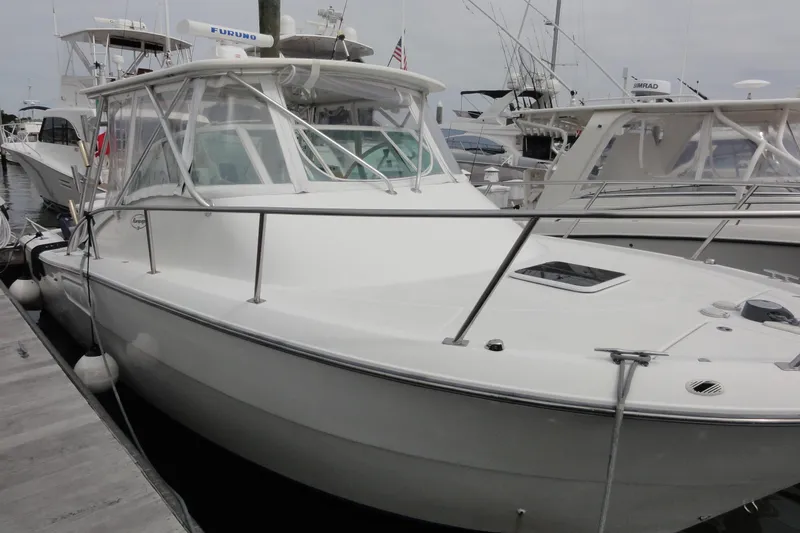 Slide: The Image of 2002 Rampage 30 Open boat docked at marina, featuring sleek design and spacious deck. - 11