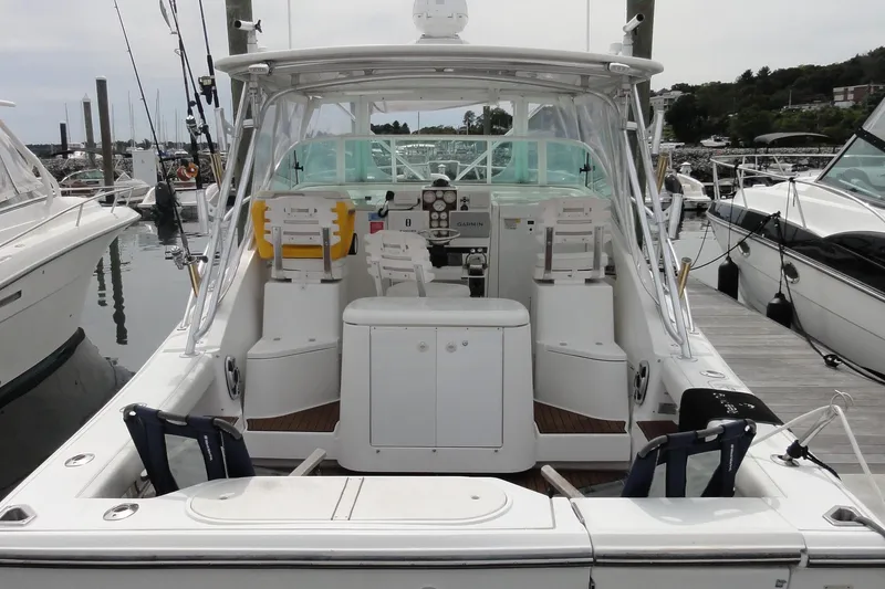 Slide: The Image of 2002 Rampage 30 Open boat docked, featuring spacious cockpit and fishing equipment. - 2