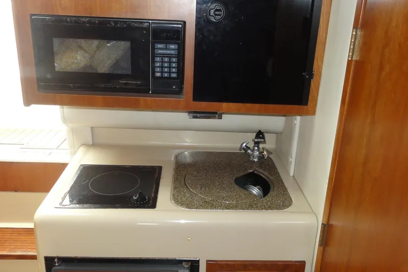 Slide: The Image of 2002 Rampage 30 Open boat kitchen with microwave, stove, and sink. - 23