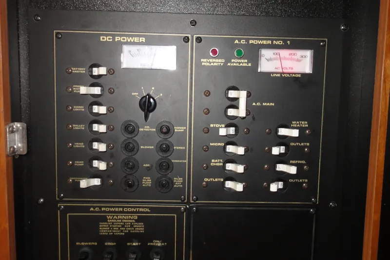 Slide: The Image of Electrical control panel on a 2002 Rampage 30 Open boat, featuring DC and AC power switches. - 25
