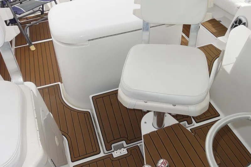 Slide: The Image of 2002 Rampage 30 Open boat interior with white seating and wood-patterned flooring. - 28