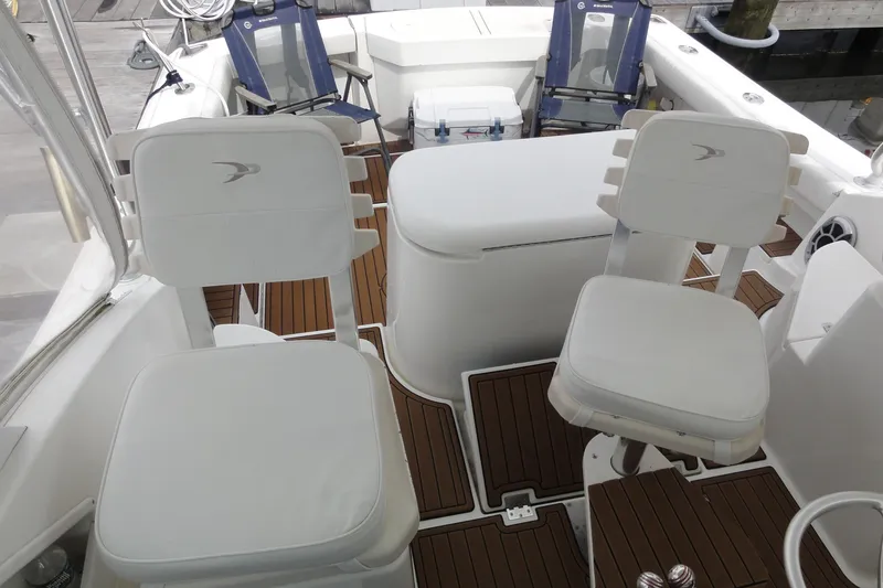 Slide: The Image of 2002 Rampage 30 Open boat interior with white seating and wooden flooring. - 29