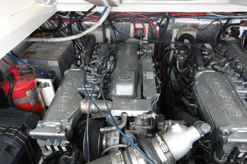 Slide: The Image of Engine compartment of a 2002 Rampage 30 Open boat, featuring dual engines and wiring. - 30