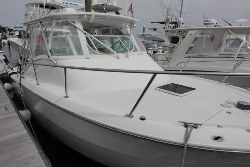 Slide: The Image of 2002 Rampage 30 Open boat docked at marina, featuring sleek design and spacious deck. - 8