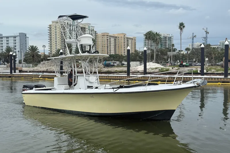 The Image of 1981 T Craft Gulfstream 30 boat docked in urban marina with cityscape background. - 0