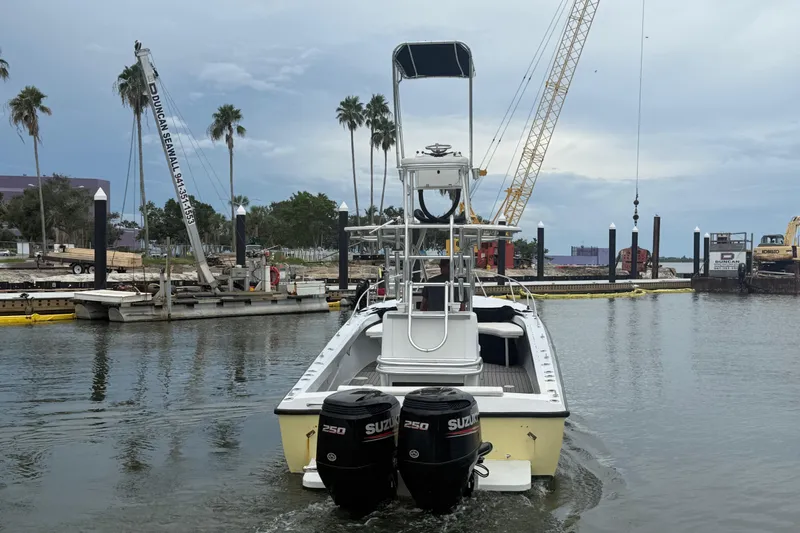 Slide: The Image of 1981 T Craft Gulfstream 30 boat with dual Suzuki engines in a marina setting. - 2
