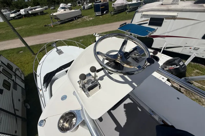 Slide: The Image of 1981 T Craft Gulfstream 30 boat helm with steering wheel and controls, parked outdoors. - 21