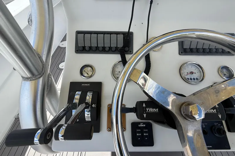Slide: The Image of 1981 T Craft Gulfstream 30 boat dashboard with steering wheel and control levers. - 32