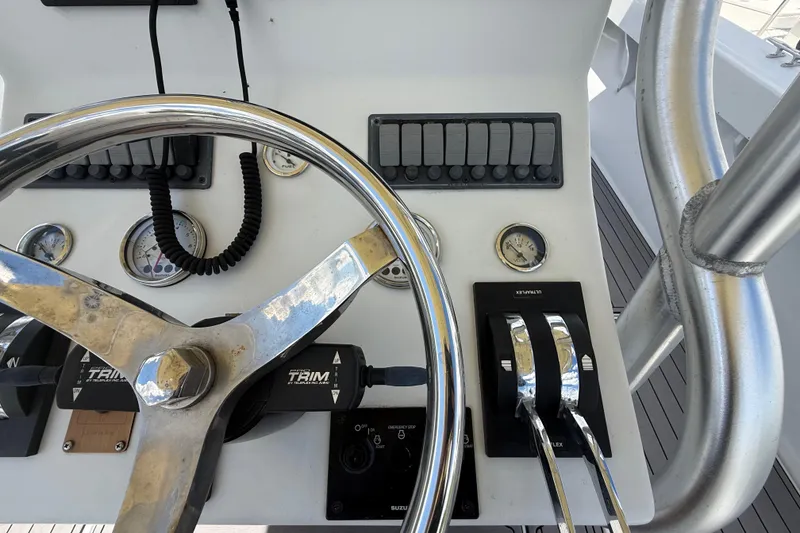 Slide: The Image of 1981 T Craft Gulfstream 30 boat dashboard with steering wheel and control levers. - 33