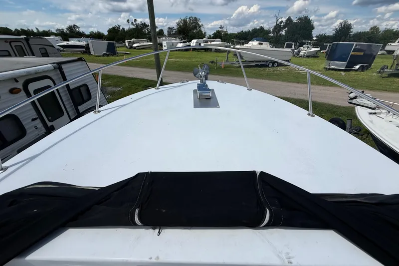 Slide: The Image of 1981 T Craft Gulfstream 30 boat deck, surrounded by trailers and boats under a cloudy sky. - 49