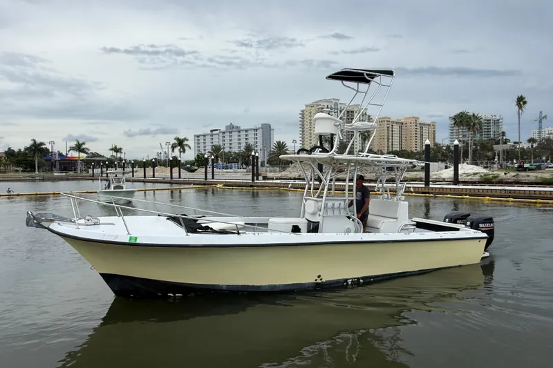 Slide: The Image of 1981 T Craft Gulfstream 30 boat docked in a marina with cityscape background. - 6