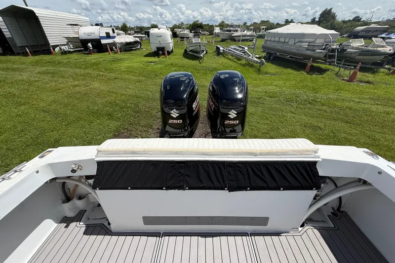 Slide: The Image of 1981 T Craft Gulfstream 30 boat with dual Suzuki 250 outboard motors in a grassy storage area. - 68