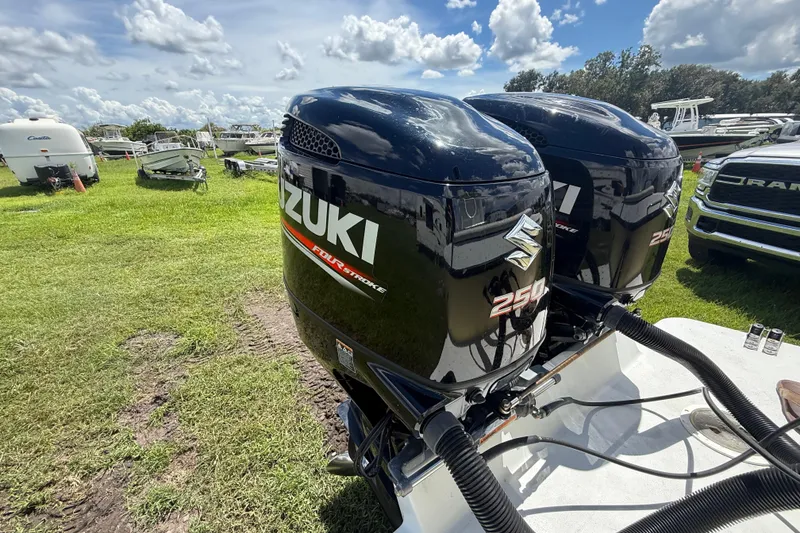 Slide: The Image of Twin Suzuki 250 outboard engines on a 1981 T Craft Gulfstream 30 boat, grassy field background. - 70