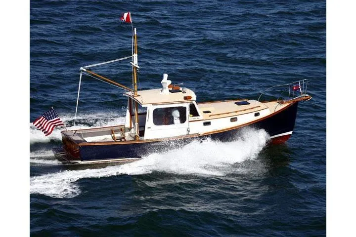 Slide: The Image of 1994 John Williams Stanley 36 boat cruising on open water, displaying American flag. - 0