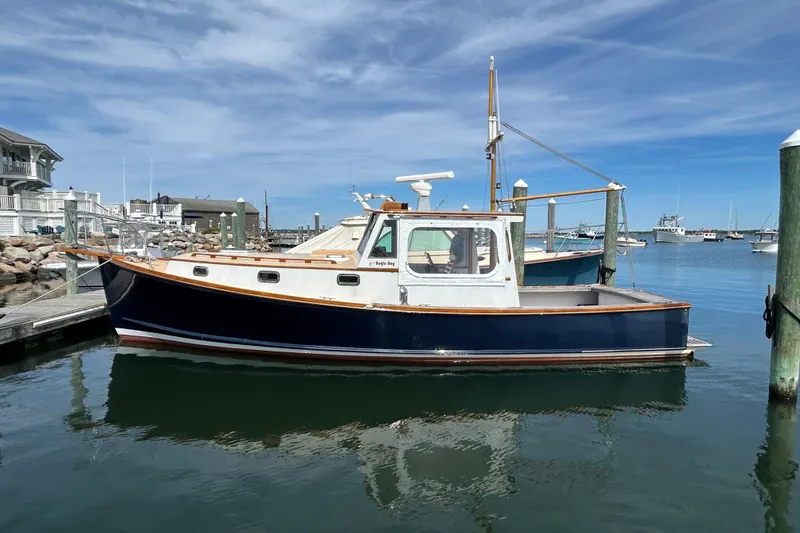Slide: The Image of 1994 John Williams Stanley 36 boat docked in a serene marina under a clear blue sky. - 3