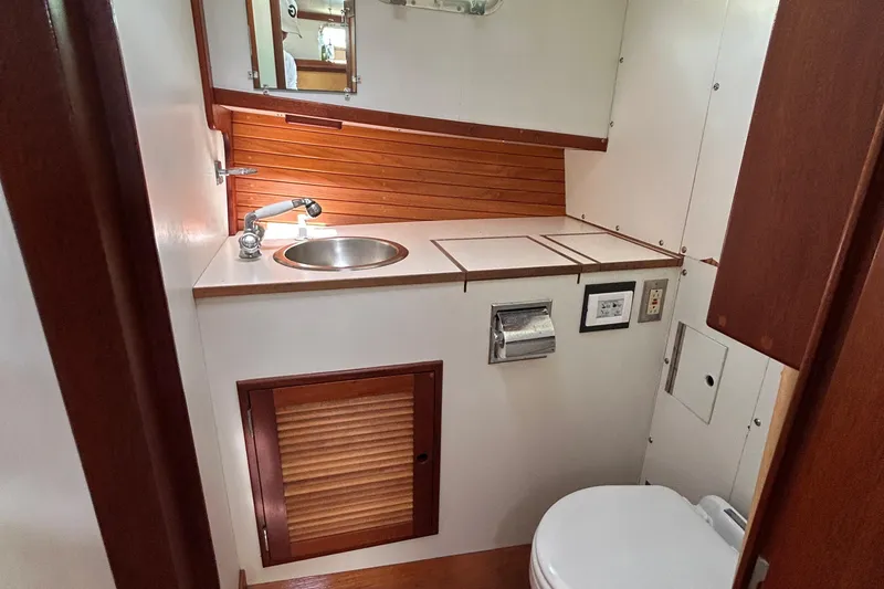 Slide: The Image of Compact boat bathroom with sink, toilet, and wood accents in a 1994 John Williams Stanley 36. - 9
