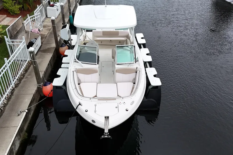 Slide: The Image of 2019 Robalo R247 Dual Console boat docked in a canal, aerial view. - 12