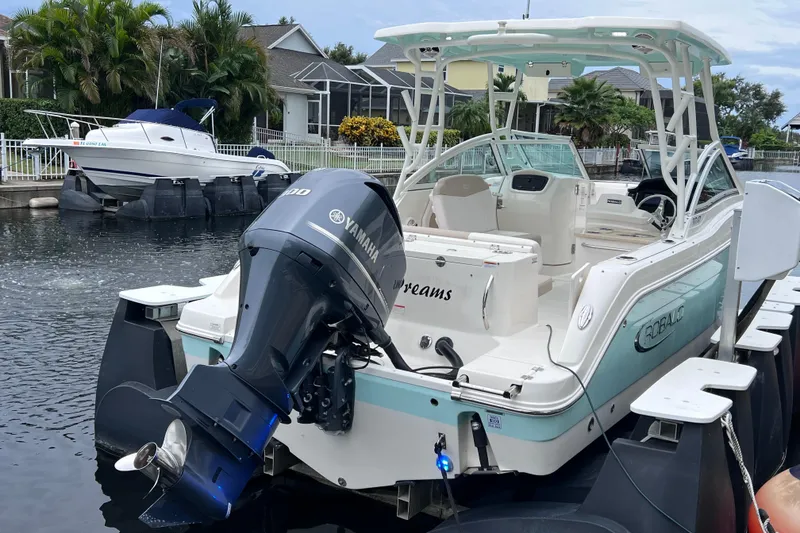 Slide: The Image of 2019 Robalo R247 Dual Console boat docked with Yamaha outboard motor. - 16
