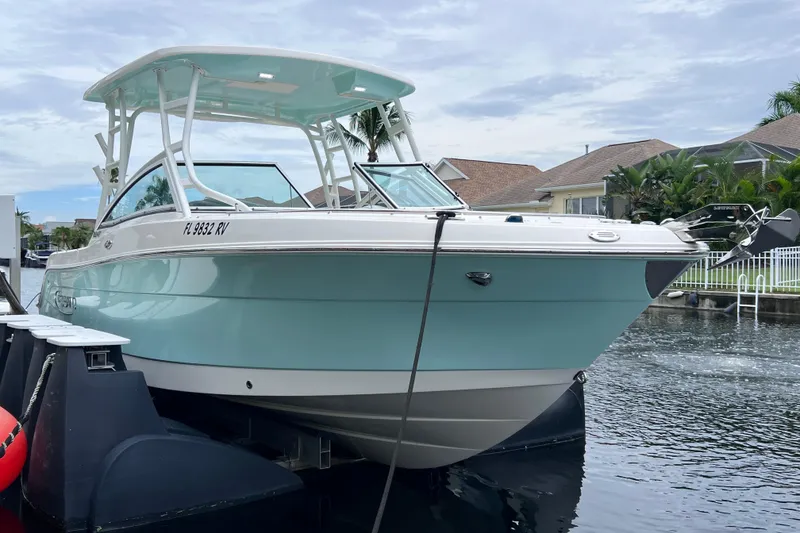 Slide: The Image of 2019 Robalo R247 Dual Console boat docked in a residential canal setting. - 17
