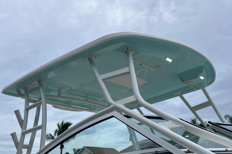 Slide: The Image of 2019 Robalo R247 Dual Console boat with sleek hardtop design against cloudy sky. - 19