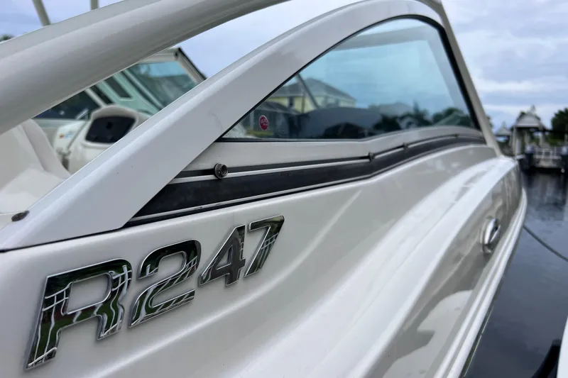 Slide: The Image of 2019 Robalo R247 Dual Console boat close-up, showcasing sleek design and branding. - 21