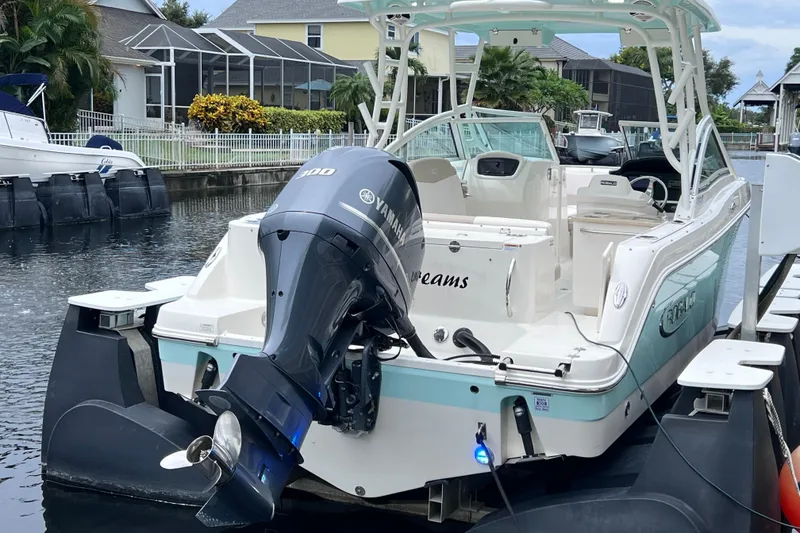 Slide: The Image of 2019 Robalo R247 Dual Console boat with Yamaha engine docked in a canal. - 22