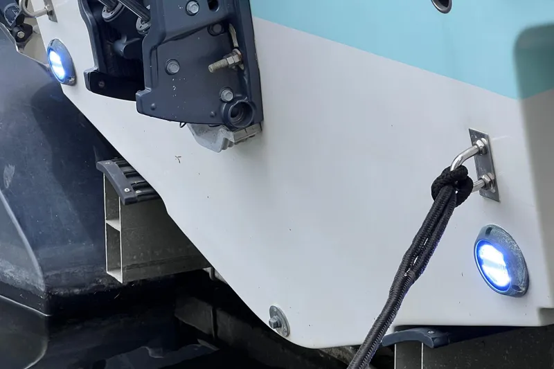 Slide: The Image of 2019 Robalo R247 Dual Console boat stern with blue LED lights and mooring line. - 23