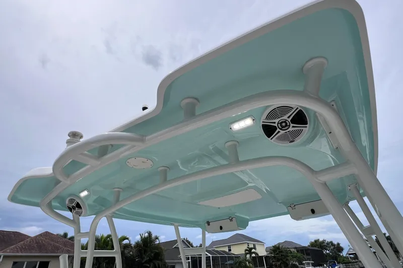 Slide: The Image of 2019 Robalo R247 Dual Console boat top with speakers and lights, under a cloudy sky. - 27