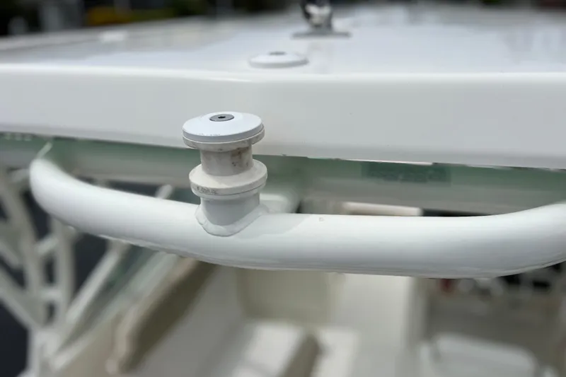 Slide: The Image of Close-up of a 2019 Robalo R247 Dual Console boat's white railing and fitting. - 28