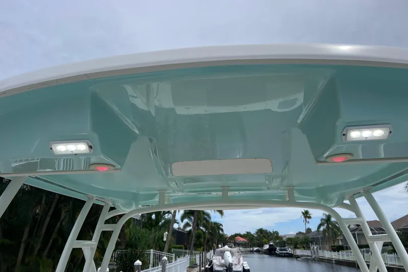 Slide: The Image of 2019 Robalo R247 Dual Console boat canopy with integrated LED lights, docked by a canal. - 31