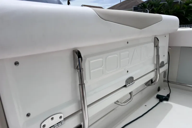 Slide: The Image of 2019 Robalo R247 Dual Console boat interior, featuring sleek white seating and stainless steel hardware. - 33