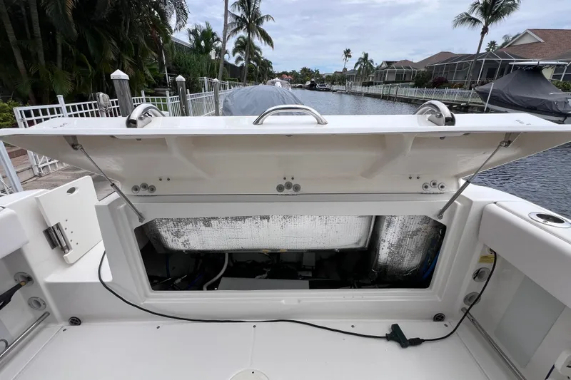 Slide: The Image of 2019 Robalo R247 Dual Console boat with open storage compartment by a canal. - 36