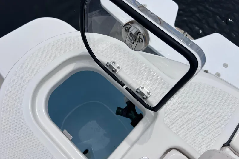 Slide: The Image of 2019 Robalo R247 Dual Console boat hatch open, showing interior compartment. - 37