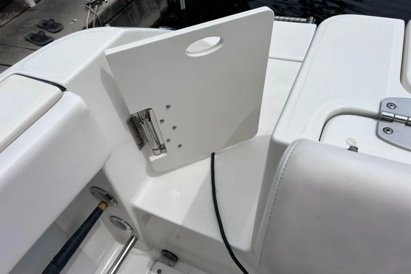 Slide: The Image of 2019 Robalo R247 Dual Console boat interior with white seating and storage compartment. - 38