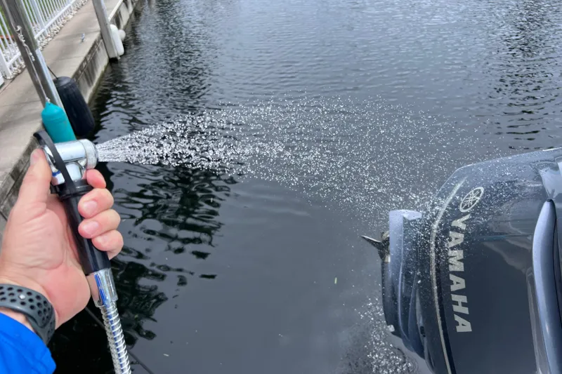 Slide: The Image of Hand spraying water on Yamaha outboard motor of 2019 Robalo R247 Dual Console boat. - 39