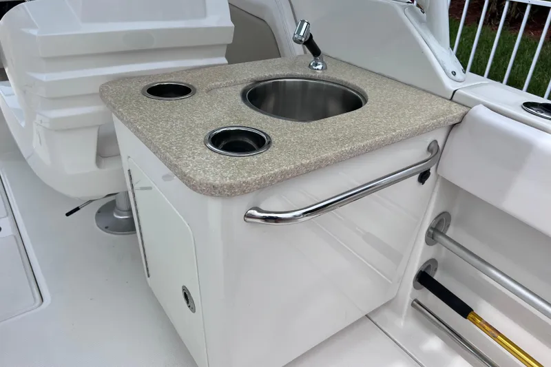 Slide: The Image of 2019 Robalo R247 Dual Console boat sink and countertop with cup holders. - 40