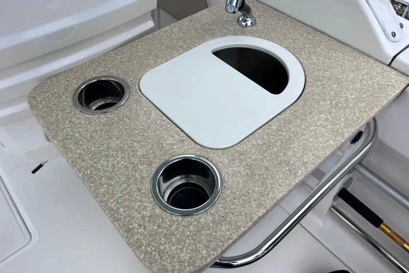 Slide: The Image of 2019 Robalo R247 Dual Console boat sink with cup holders and beige countertop. - 41