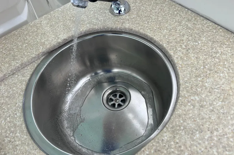 Slide: The Image of Stainless steel sink with running water in 2019 Robalo R247 Dual Console boat. - 42