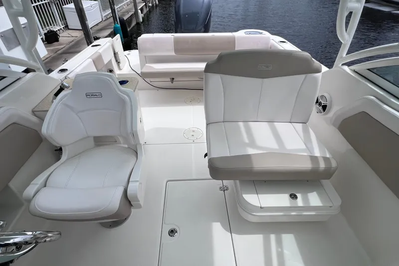 Slide: The Image of 2019 Robalo R247 Dual Console boat interior with white seating and water view. - 47