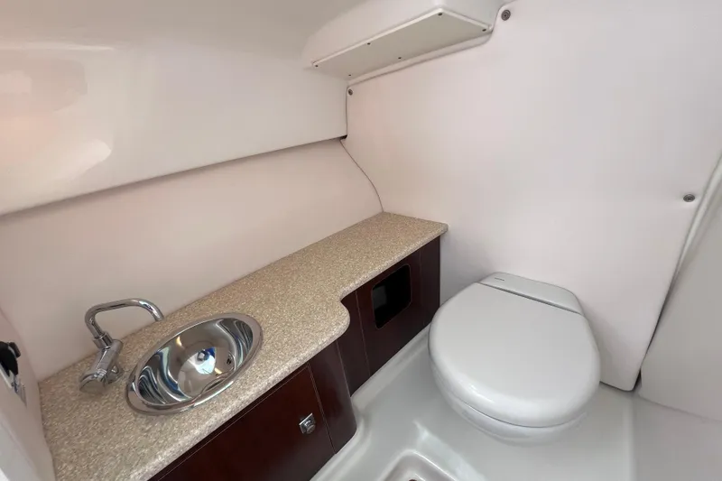 Slide: The Image of 2019 Robalo R247 Dual Console boat interior with sink and toilet. - 51